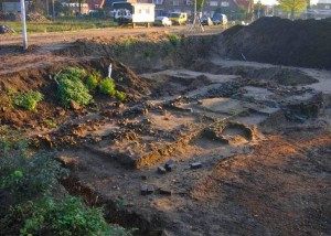 Foto van de plek waar de fundering van Romeinse villa is gevonden. Het gespannen lijntje geeft ongeveer de rand van de vloer aan, en achterin, tussen de twee losse bakstenen door, lag de ‘vloerverwarming’, een stelsel van open buizen onder de vloer door waarin hete lucht werd gestookt. (Foto: Michel Ketelaars)