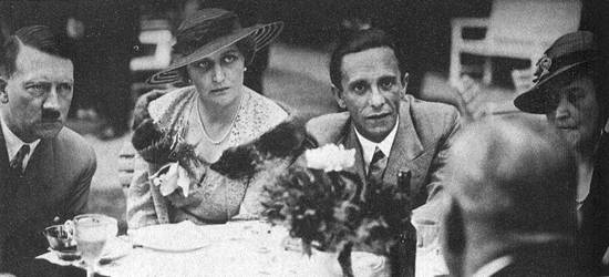 Hitler (l), Magda (m) en Joseph Goebbels (r) tijdens een theepartijtje in de tuin van de Rijkskanselarij (1934)