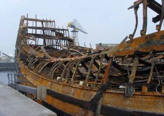 De overblijfselen van het nagebouwde schip nadat het op 30 juli 2009 vrijwel volledig uitbrandde. (CC BY-SA 3.0 - Vic van Werkhooven - wiki)