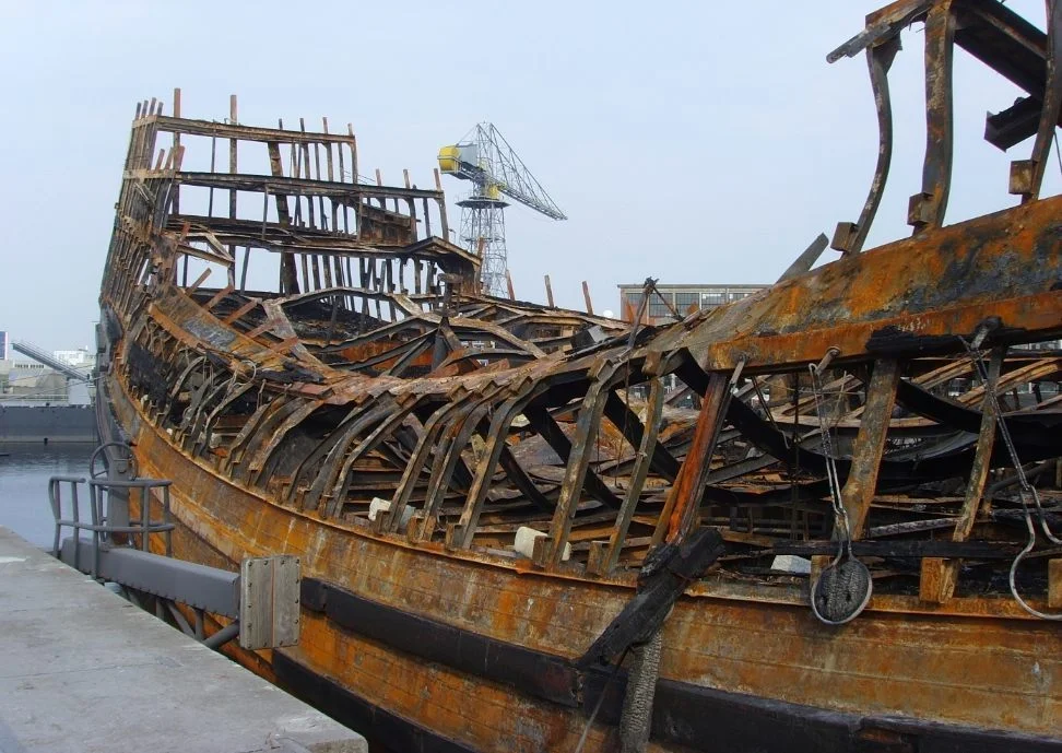 De overblijfselen van het nagebouwde schip nadat het op 30 juli 2009 vrijwel volledig uitbrandde. (CC BY-SA 3.0 - Vic van Werkhooven - wiki)