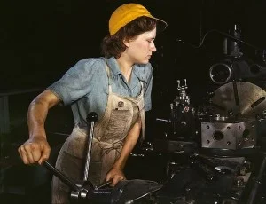 Een levende ‘Rosie the Riveter’ aan het werk in een fabriek – Foto: Hollem, Howard R.