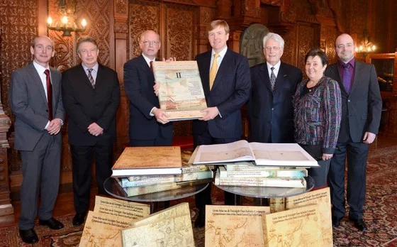 Prins Willem-Alexander ontvangt een negendelige historische atlas uit handen van Henk Ottens, voorzitter van het KNAG – Foto: ANP Royal Images – Lex van Lieshout
