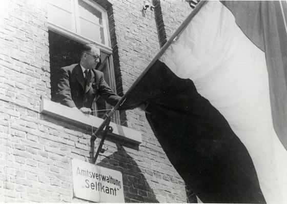 Landdrost Hubert Dassen plaatst Nederlandse vlag – Bron: Euregionaal Historisch Archief Sittard-­Geleen