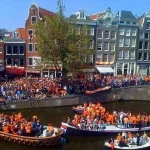 Op Koninginnedag kleuren de Amsterdamse grachten oranje