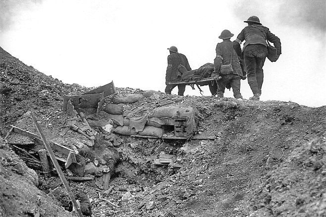 Soldaten halen een gewonde Brit uit een veroverde Duitse loopgraaf - Foto:  Imperial War Museums