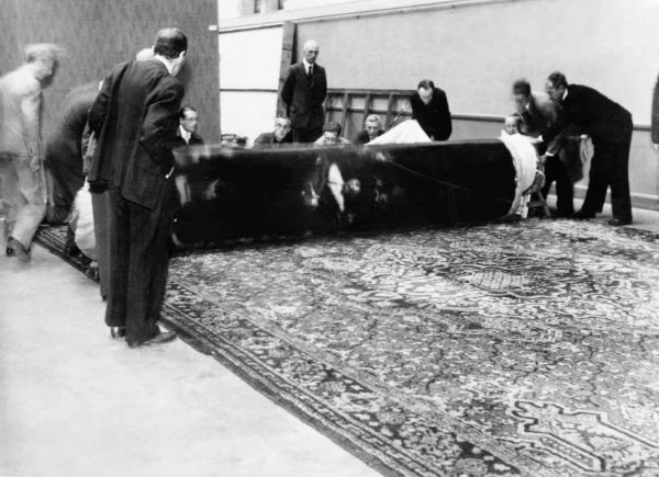 De Nachtwacht keert terug in het Rijksmuseum. Het doek wordt op 30 juni 1945 voorzichtig afgerold na enkele jaren opgerold bewaard te zijn geweest, op het laatst in een mergelgrot bij Maastricht. - Foto: U.S. National Archives