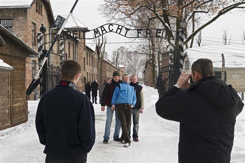 Toeristen voor de ingang van het hoofdkamp van Auschwitz. © Hans Citroen