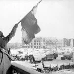 Sovjet-soldaat wappert met een vlag voor de overwinning om Stalingrad op 2 februari 1943