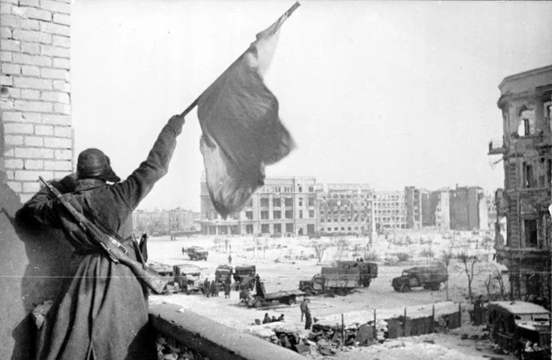 Sovjet-soldaat wappert met een vlag voor de overwinning om Stalingrad op 2 februari 1943
