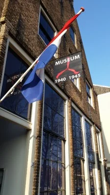 De Hollandse driekleur wappert vrolijk in het zonnetje boven de museumingang
