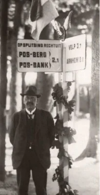 Gerard Pos  poseert bij een door het ANWB ontworpen wegwijzer naar de Posbank.