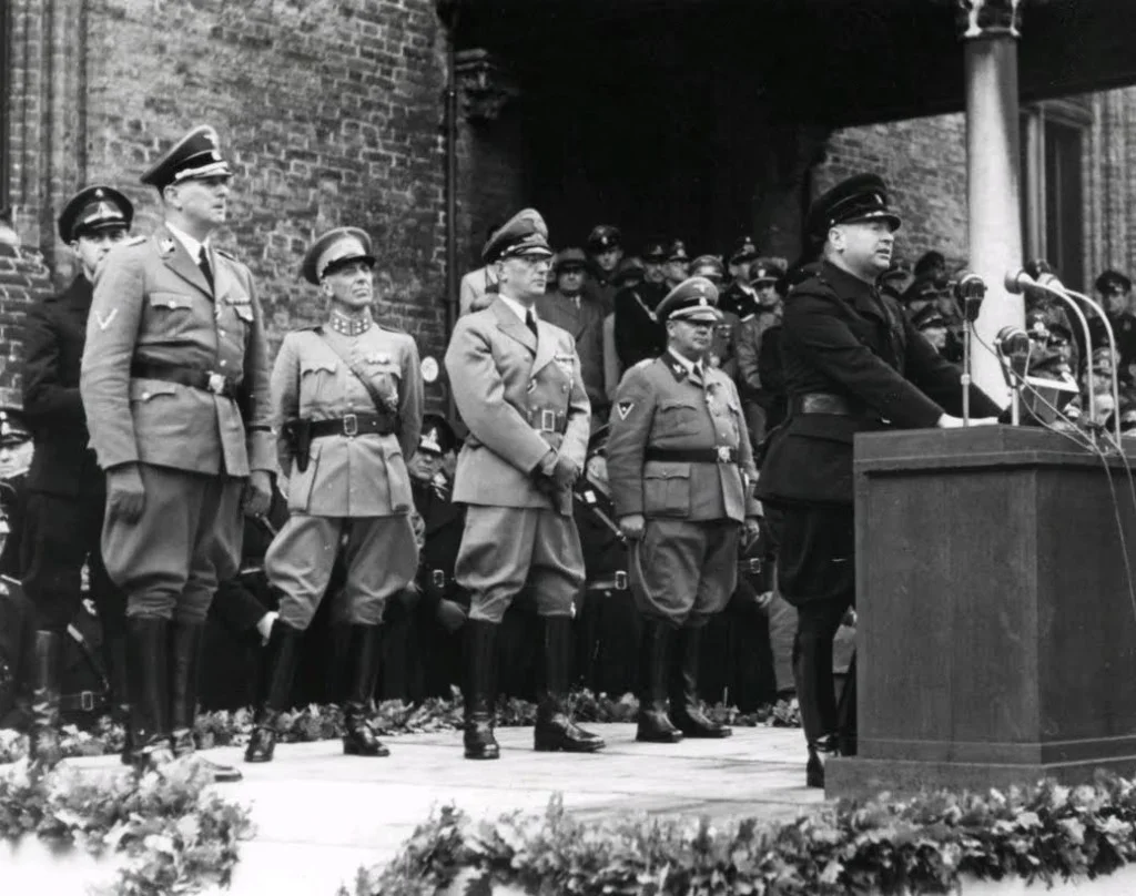 Hendrik Seyffardt bij een toespraak van Mussert in 1941. Seyffardt staat achteraan, tweede van links. Bron: Wikipedia.