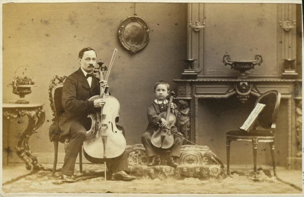 Maurits Verveer, Portret van man met cello en jongen met viool in huisinterieur, 1860-1880. Rijksprentenkabinet, Amsterdam