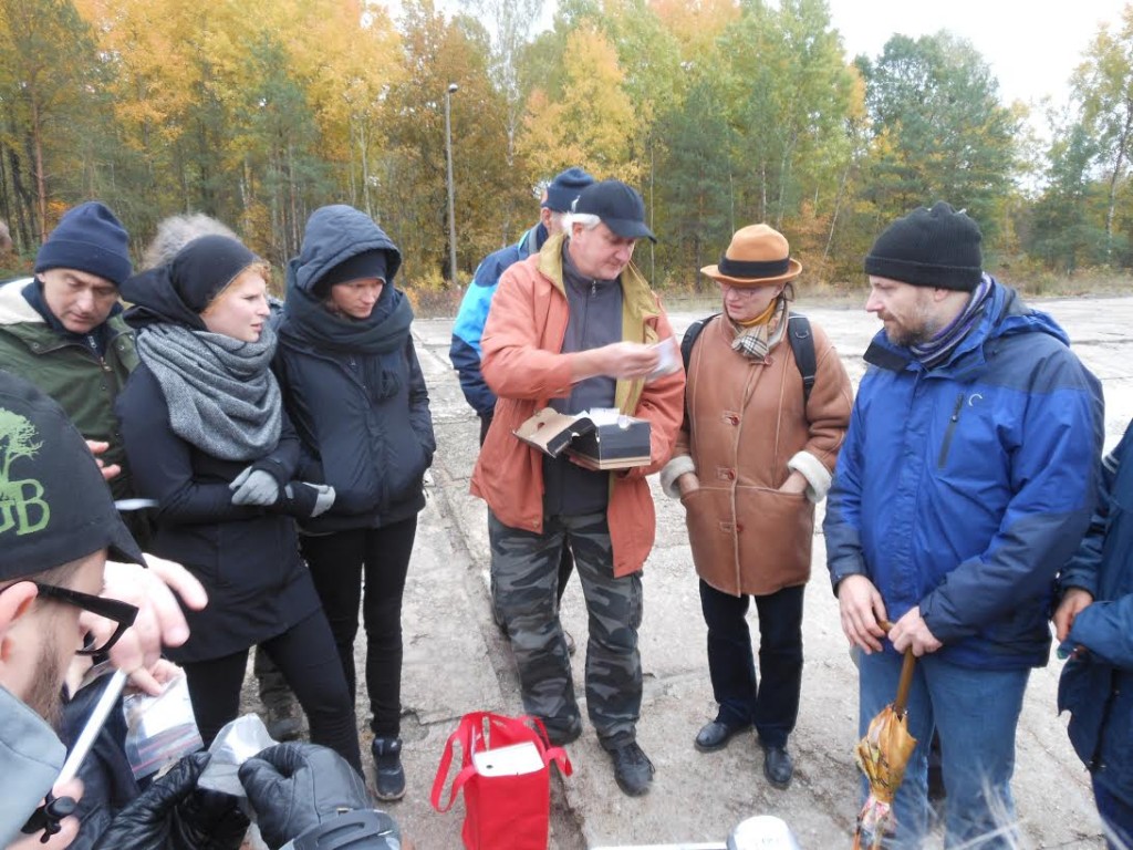 Archeoloog Wojtek Mazurek toont enkele artefacten aan de deelnemers