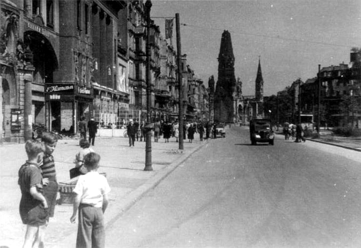 Kurfürstendamm, juli 1945. Op de achtergrond de zwaar gehavende Kaiser Wilhelm Gedächtniskirche. (Bundesarchiv, Bild 204-003 / CC-BY-SA)