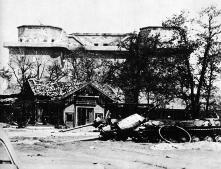 Op de voorgrond: achtergelaten beschadigd oorlogsmaterieel in de zoo na de Slag om Berlijn. Het gebouw op de achtergrond is de zogenoemde Zoo-Flakbunker, een gigantische betonnen schuilbunker voor burgers met bovenop luchtafweergeschut. (Publiek Domein / Wikimedia Commons)