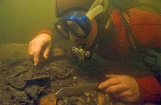 Een onderwaterarcheoloog bovenop de afvalhoop van Ceuclum. Foto: Willem van Kolvoort.