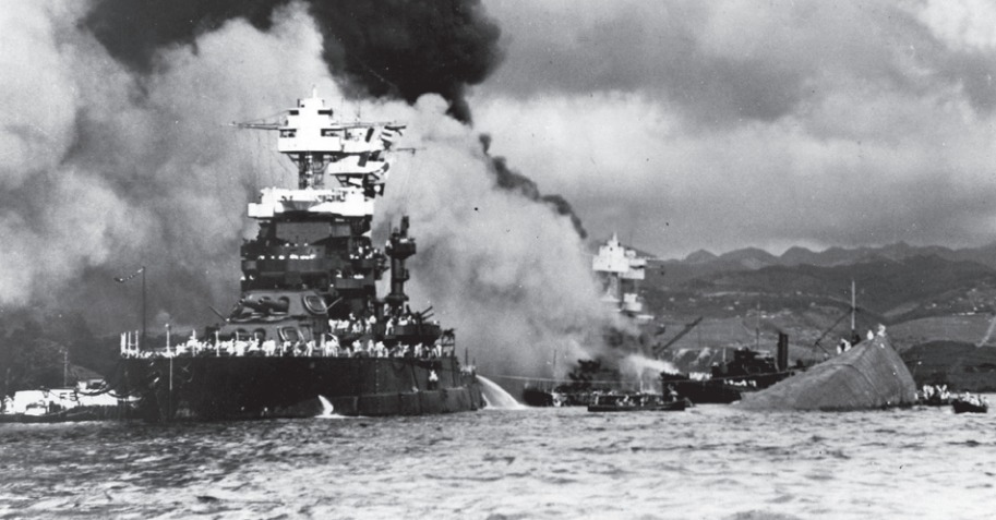 De aanval op Pearl Harbor, 7 december 1941. De uss Maryland naast de gekapseisde uss Oklahoma; de uss West Virginia staat in brand.  © Naval Historical Foundation, Washington DC