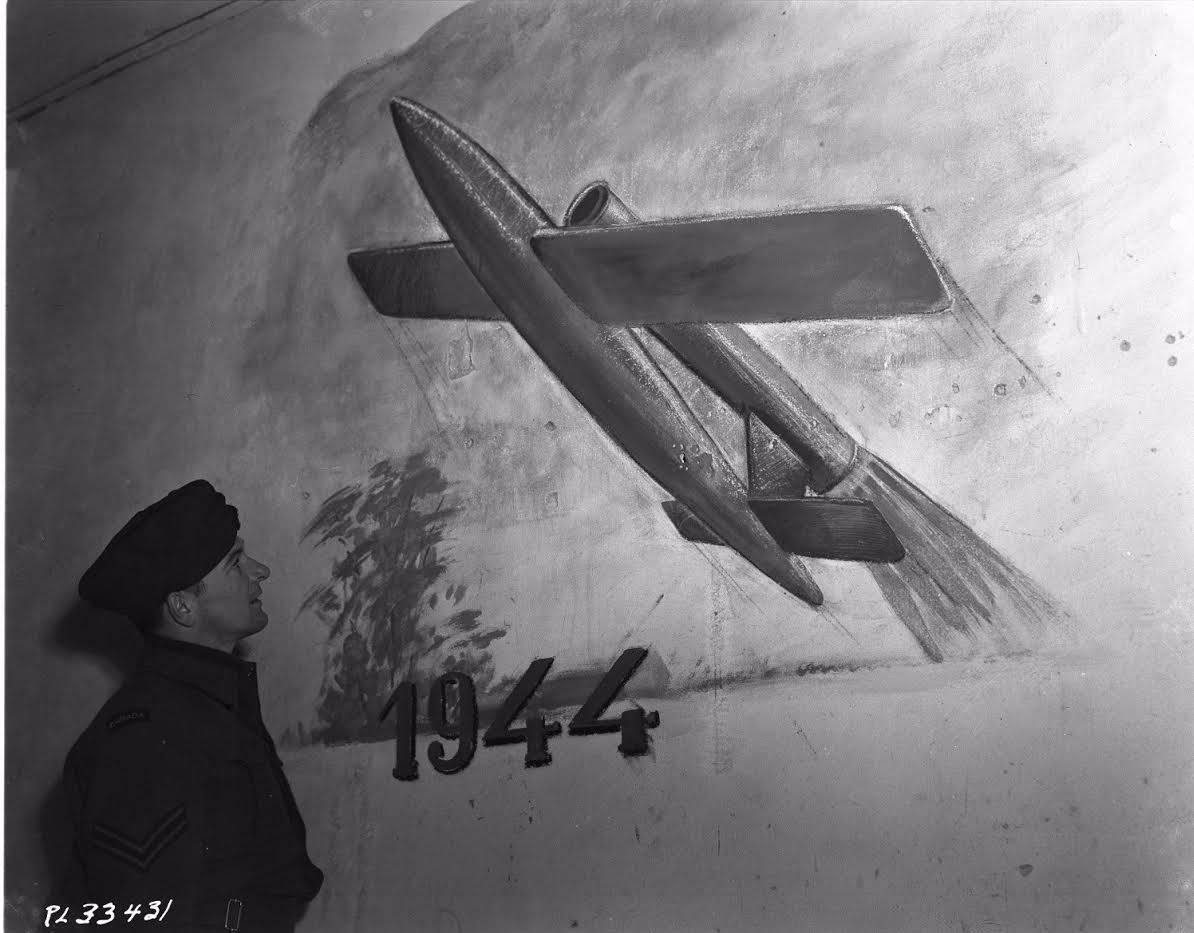 Geallieerde militair bekijkt een muurschildering van een V-1 collectie (collectie Canadian Forces Joint Imagery Centre)