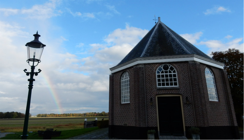 Kerkje van Schokland, met een regenboog op de achtergrond (Historiek)