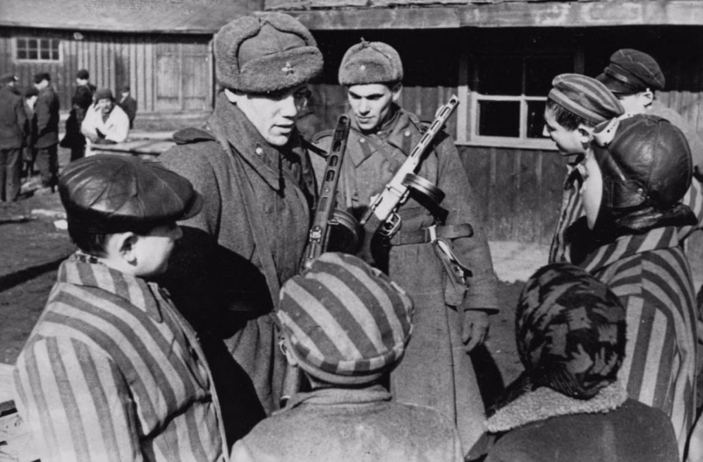 Soldaten van het Rode Leger met jonge gevangenen van Auschwitz bij de bevrijding. (Publiek domein)