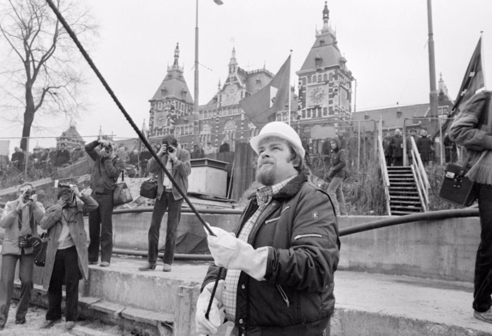 Jan Schaefer slaat de eerste paal voor de herbouw van het Noord-Zuid Hollandsch Koffiehuis, 1980 (cc - Nationaal Archief - Anefo - Rob Bogaerts)
