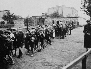 Kinderen in het getto van Łódź op weg naar de treinen die hen naar de vernietigingskampen brengen (USHMM)