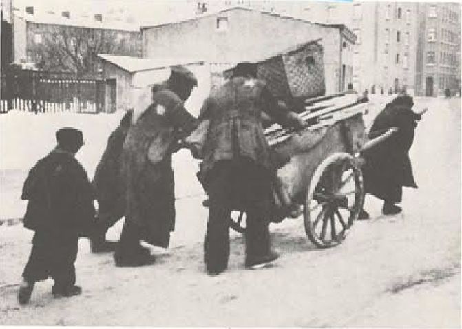 Een joodse familie op weg naar het getto is. Opvallend is dat de joodse bevolking zowel op de voorzijde als op de achterzijde een jodenster moest dragen.  (The Chronicle of the Lodz Ghetto - Yale, 1987)