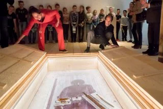 Janneke Berkelbach (links) van de Nationale Archeologiedagen en gedeputeerde Henri Swinkels openen het eerste graf en onthullen daarmee de Merovingische schat in het Museum voor Religieuze Kunst in Uden