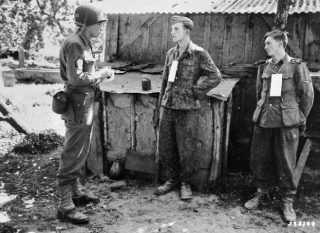 Martin Selling ondervraagt gevangengenomen Duitse ss’ers nabij het front in Frankrijk, 1944. (U.S. Army Signal Corps)