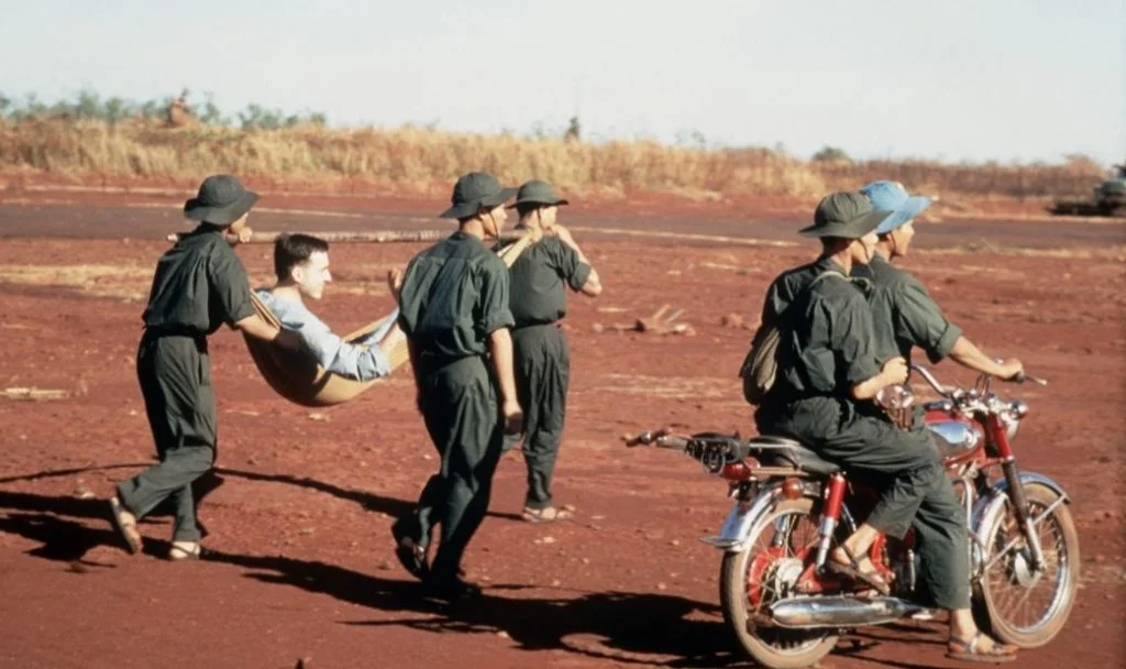 Vietcongsoldaten dragen een doek met een Amerikaanse krijgsgevangene naar een uitwisselingspunt in ruil voor de vrijlating van een aantal Vietcongsoldaten en soldaten van het Noord-Vietnamese leger (1973) - wiki