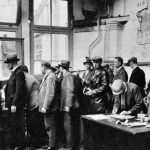 De crisisjaren (1929-1939) - De Grote Depressie - Werklozen in een stempellokaal in Amsterdam-Noord, 1933 (Nationaal Archief - wiki)