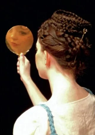 Een Romeinse schoonheid kijkt in de spiegel.