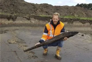 Jeroen Loopik van ADC met een deel van een houten paal van de Romeinse weg  (Foto Provincie Zuid-Holland)