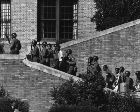 De Little Rock Nine op weg naar school, onder begeleiding van militairen van de 101st Airborne Division (Publiek Domein - US Army)