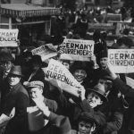 Juichende burgers in New York - "Germany surrenders" (Publiek Domein - wiki - National Archives)
