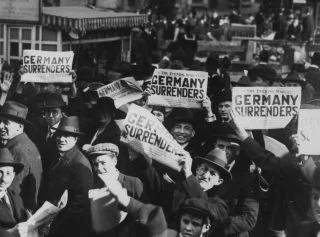 Juichende burgers in New York - "Germany surrenders" (Publiek Domein - wiki - National Archives)