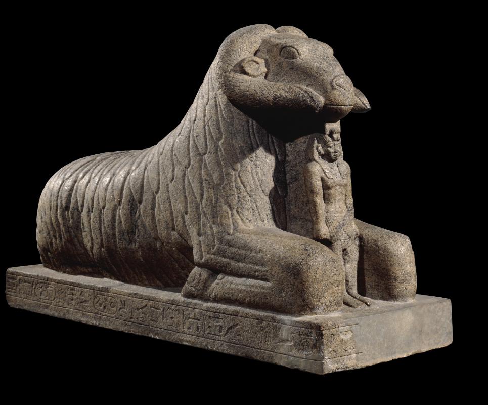 Het beeld van Taharka, uit British Museum in Londen, was te zwaar om naar de eerste verdieping te takelen waar de rest van de goden van Egypte te vinden zijn, en staat bij de ingang.Voor de borst van een ram staat de Nubische koning Taharka. De ram is het heilige dier van de god Amon; de farao geldt als Amons zoon op aarde. Tussen 722 en 655 v. Chr. veroverden de Nubiërs Egypte en heersten er als rechtmatige farao’s. (Foto: The Trustees of the British Museum - RMO)