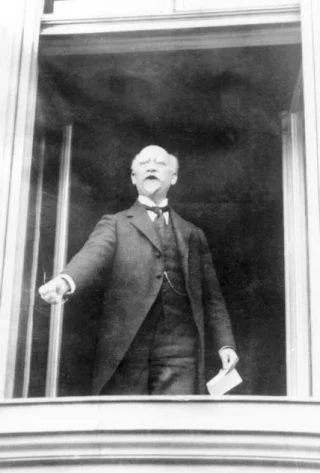 Philipp Scheidemann, staand in een raam van de Rijkskanselarij, roept de Duitse republiek uit op 9 november 1918 (CC BY-SA 3.0 de - Bundesarchiv)