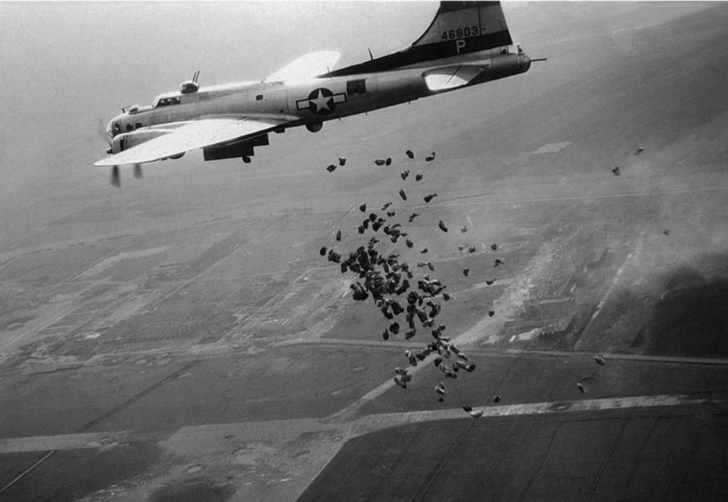 Een Amerikaanse B-17 lost in het kader van operatie Chowhound in mei 1945 boven het totaal verwoeste Schiphol een lading levensmiddelen (Publiek Domein - wiki)