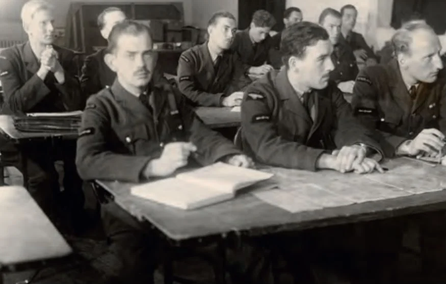 Nederlandse leerling-vliegers krijgen medio 1941 theorieles op een vliegschool. Op de voorste rij v.l.n.r. Kees van Eendenburg, Jan Flinterman en Eugène van der Togt. (NIMH)