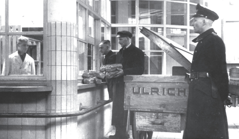 Rotterdam, maart 1945. Nadat speciaal aangewezen bakkerijen het hebben gebakken, wordt Zweeds wittebrood onder politiebegeleiding naar de klanten gebracht.  BeeldbankWO2 / niod (uit: 1945)