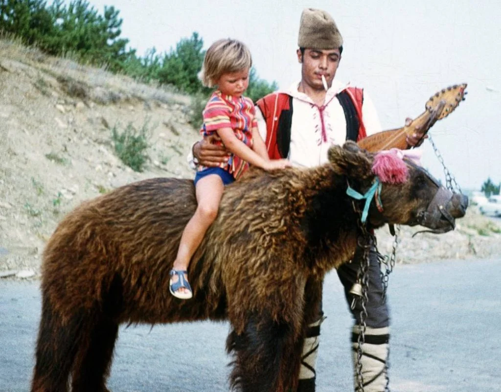 Kind op de rug van een 'dansende beer ' in Bulgarije, ca. 1970