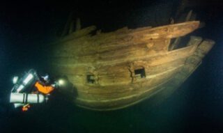 Bakboordzijde van het schip met rechts de achtersteven. Twee versierde poorten van de hutten zijn zichtbaar. Foto: Badewanne