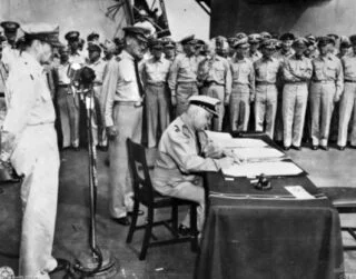 Ondertekening van de Japanse overgavedocumenten door de Nederlandse vertegenwoordiger luitenant-admiraal Conrad E.L. Helfrich 