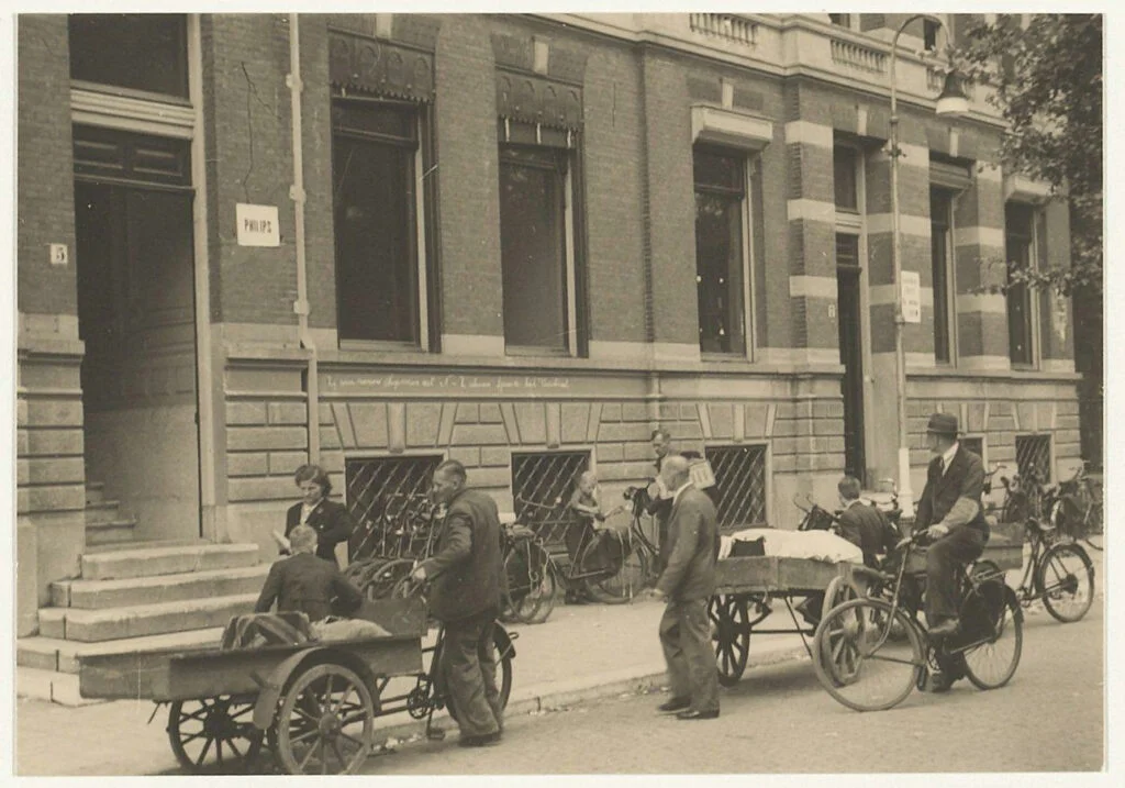 Haarlemmers komen in 1943 bij het Haarlemse politiebureau aan het Nassauplein, waar de mini-Gestapo zetelt, hun radio's inleveren. Foto Noord-Hollands Archief
