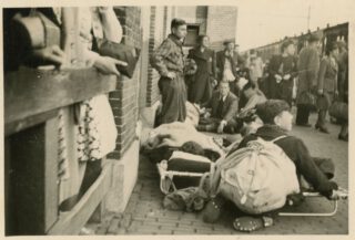 Wachtenden op het perron van Vught, 23 mei 1943. Linksvoor brancard met ernstig zieken (foto: collectie Nationaal Monument Kamp Vught).