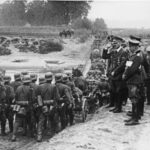 Hitler kijkt toe hoe Duitse soldaten Polen in marcheren