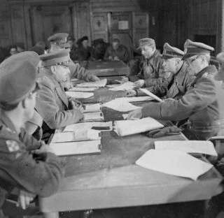 Bespreking in Hotel de Wereld in Wageningen, 5 mei 1945. Midden links Charles Foulkes, geheel links vooraan Prins Bernhard; midden rechts Johannes Blaskowitz.