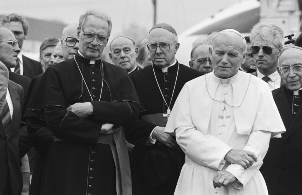 Paus Johannes Paulus II tijdens zijn bezoek aan Nederland in 1985 met de kardinalen Simonis (l) en Willebrands (m) 